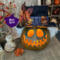 A Handmade spooky monster fall decoration with a whimsical toothy grin, a grungy top hat and candle. 